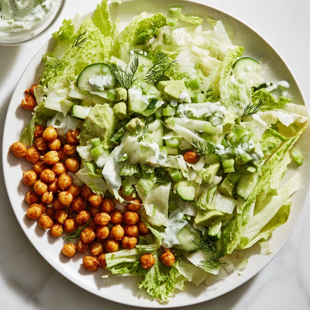 A close-up of a colorful Green Goddess Salad topped with crunchy, golden air-fried chickpeas.