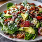 Vibrant Spring Cobb Salad with Strawberries and Avocado, featuring fresh greens, juicy berries, creamy avocado, and tangy feta.