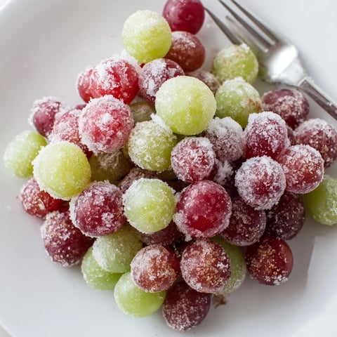 A close-up of vibrant frozen grapes, a simple and refreshing American snack.