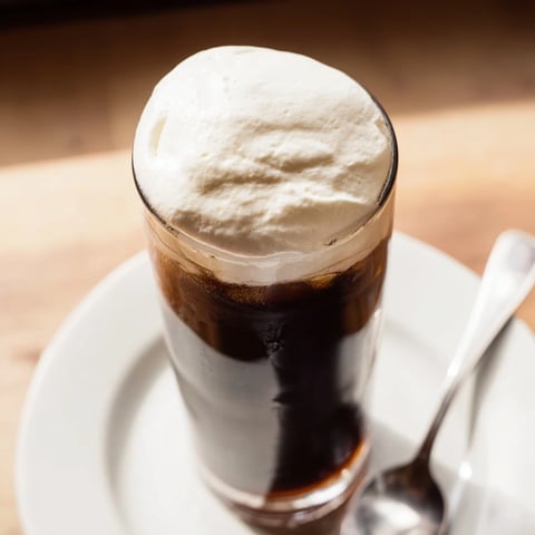 Fluffy Starbucks cold foam, swirled atop iced coffee, offering a creamy, sweet delight.