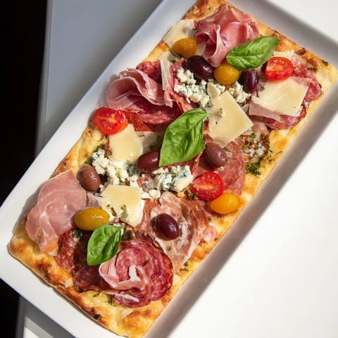Shareable The Rustic Raft appetizer features warm artisan flatbreads piled high with delectable cheeses and meats.