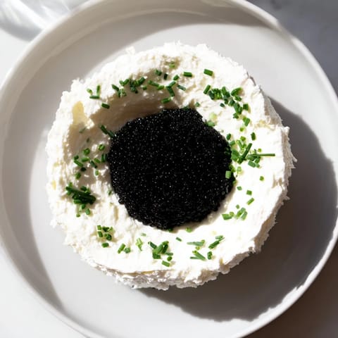 Luscious Diamond Inlay, showcasing a sparkling caviar diamond nestled in a creamy cream cheese ring and served with blinis.