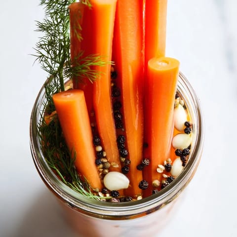 Close-up of freshly made Quick Pickled Carrot Spears with garlic and spices, perfectly chilled and ready.
