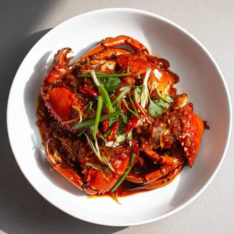 A close-up of glossy Singaporean chili crab, showcasing the spicy, savory, and sweet flavors.