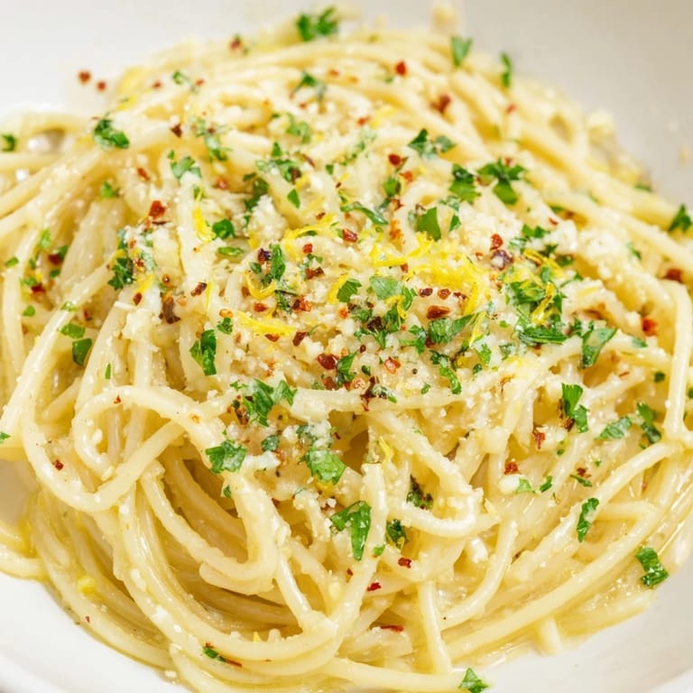 Close-up of perfectly cooked garlic butter noodles, tossed with herbs and offering delectable aromas.
