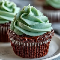 St. Patrick's Day green velvet cupcakes with cream cheese frosting, topped with festive green sprinkles.